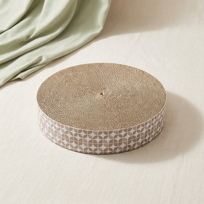 Circular corrugated cat scratching board on a clean neutral background